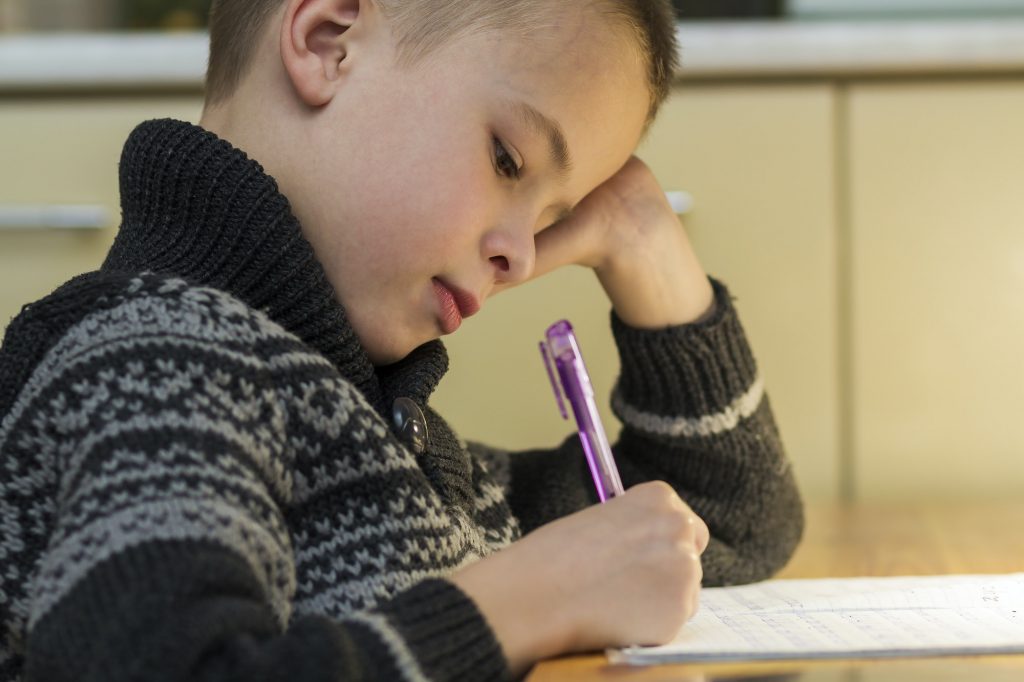 Child school age boy making his homework