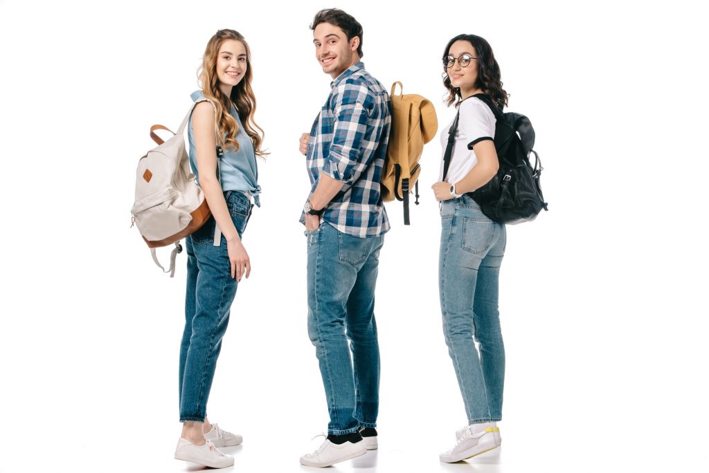 smiling multicultural students looking at camera isolated on white